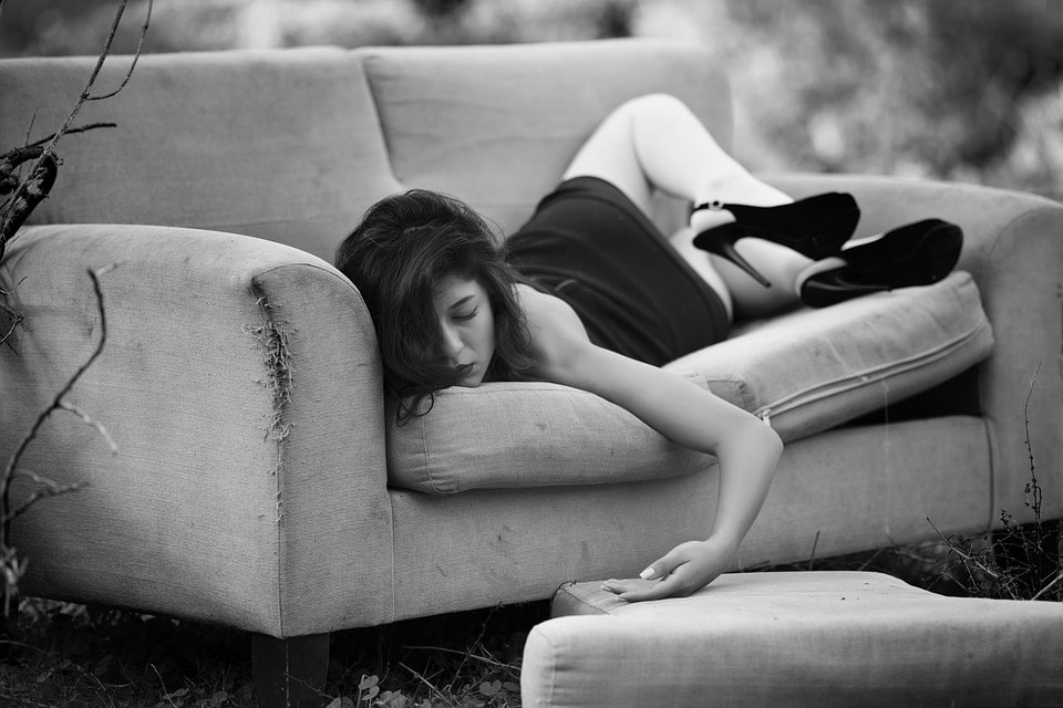 A women wearing black dress and sleeping on stomach