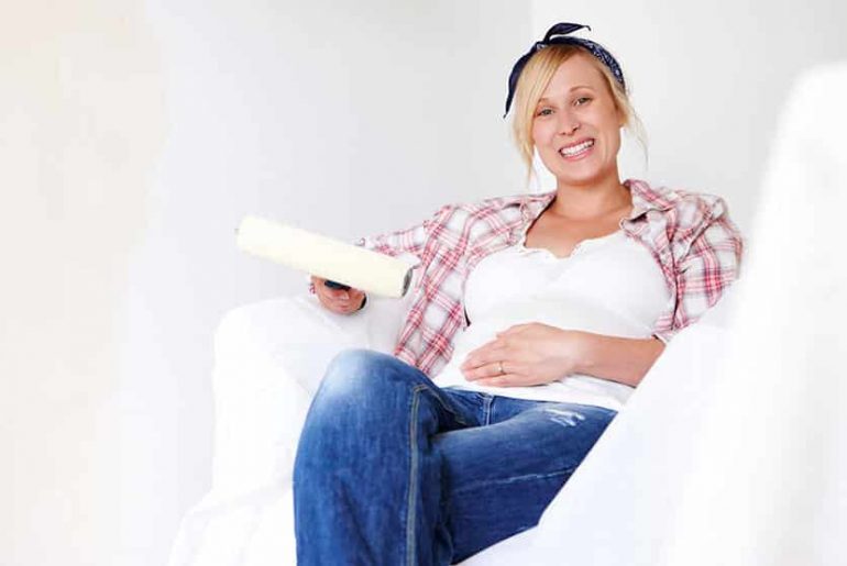 A Pregnant Woman Sitting in Newly Painted Room