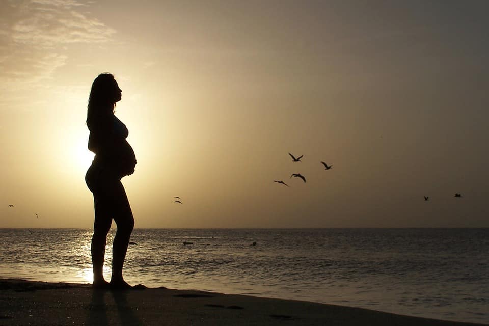 A pregnant woman relaxing herself on the beach